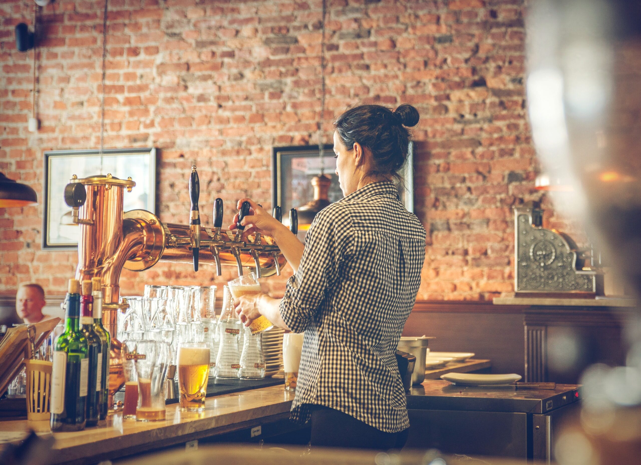 Bartender pouring drinks at restaurant with general liability coverage