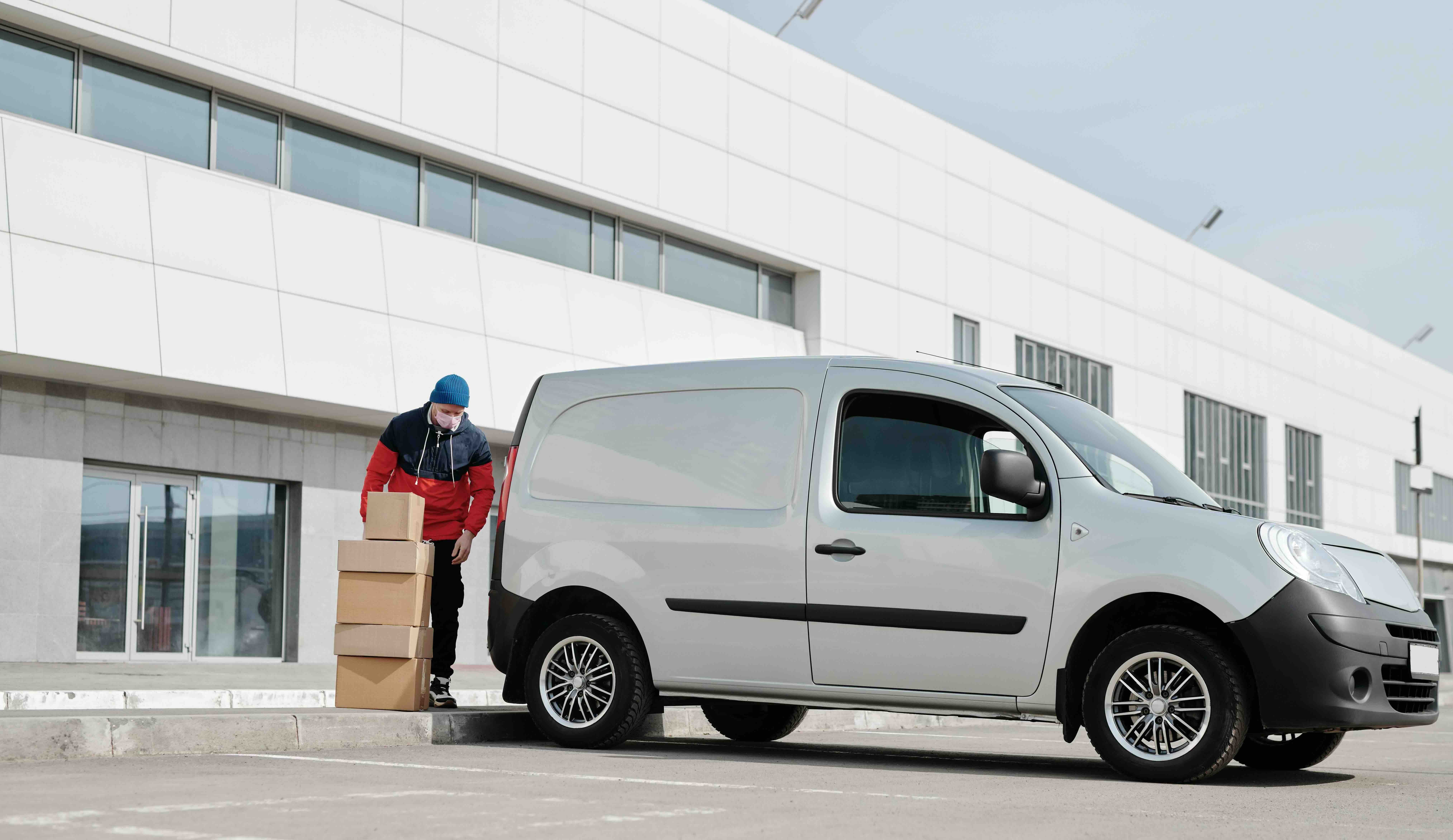 Delivery driver loading boxes into a van cover by commercial auto insurance