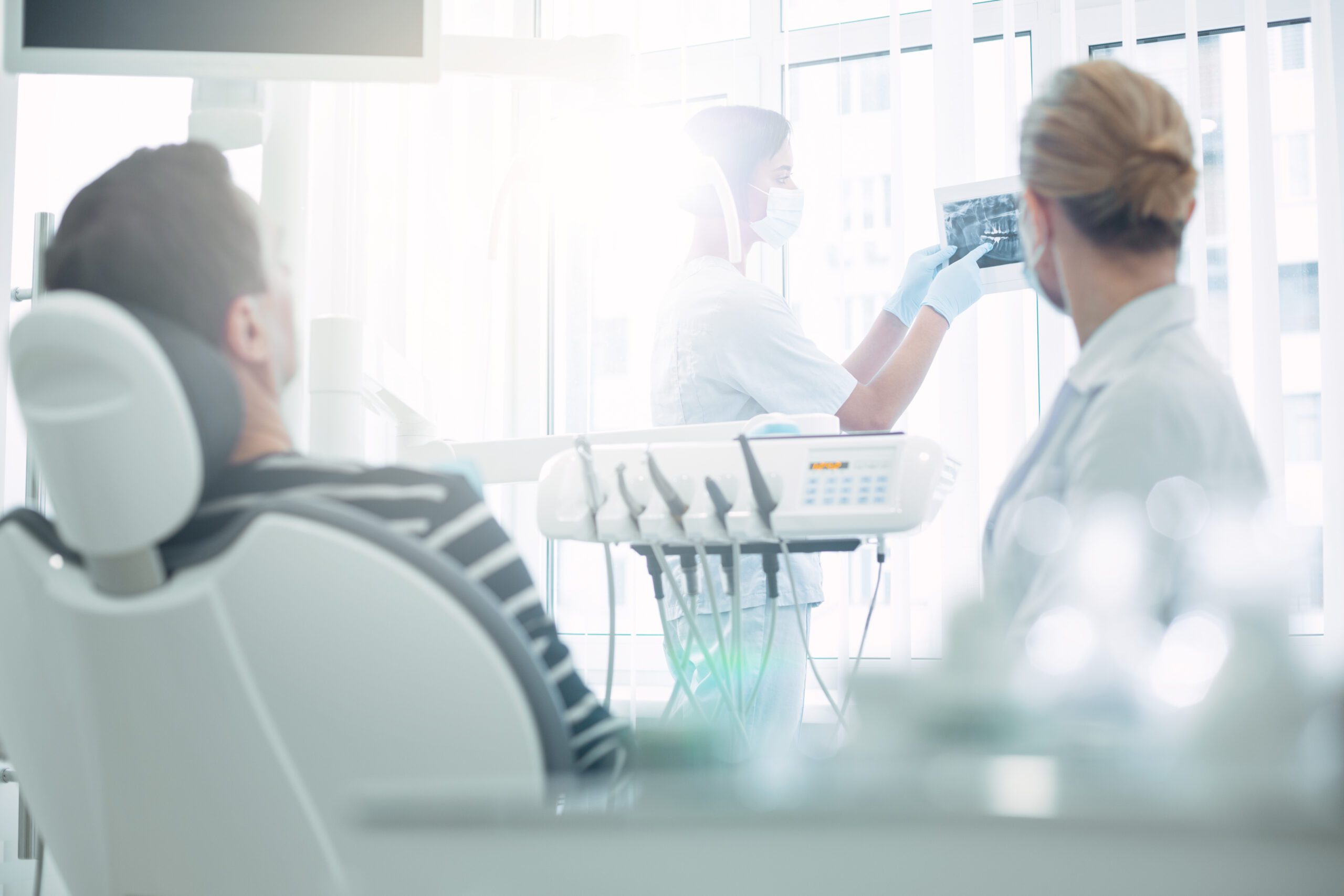 Dark-haired dentist showing teeth on the screen in Washington State